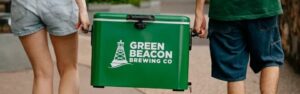 Green Beacon Teneriffe brand esky carried along a footpath by two people
