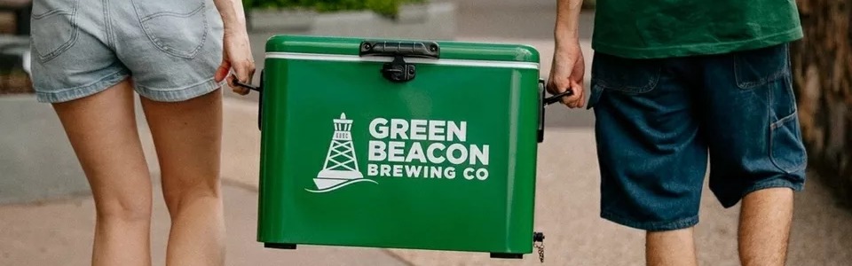 Green Beacon Teneriffe brand esky carried along a footpath by two people