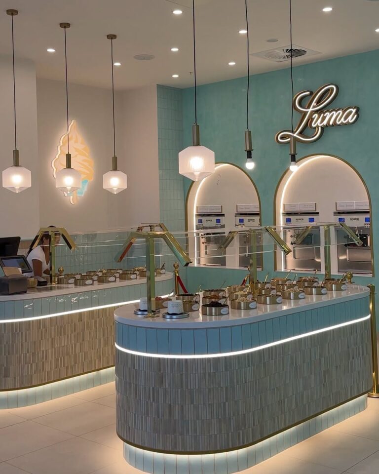 LUMA Gelato self-serve counter with bowls of toppings in front of gelato machines under a neon Luma sign